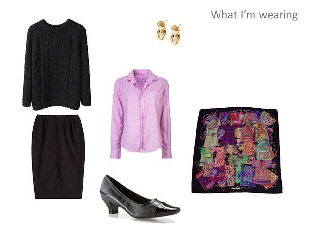 travel outfit of black cabled sweater, pink oxford shirt, black skirt and Hermes scarf