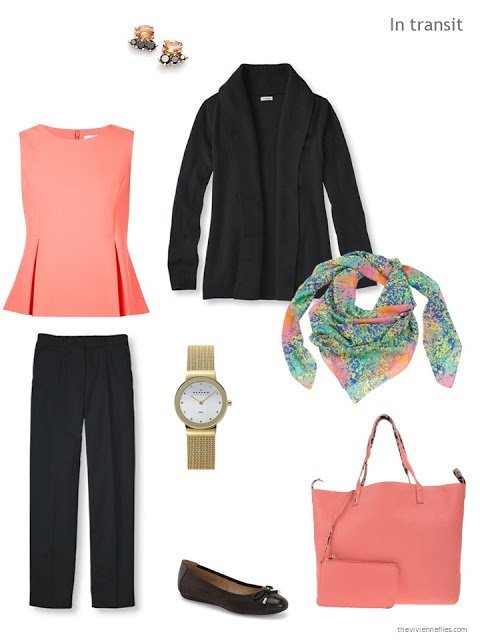 A travel outfit in black and coral, with a coral bag and multi-colored scarf.