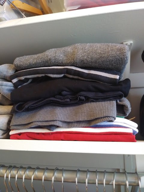 a neatly folded stock of long-sleeved shirts