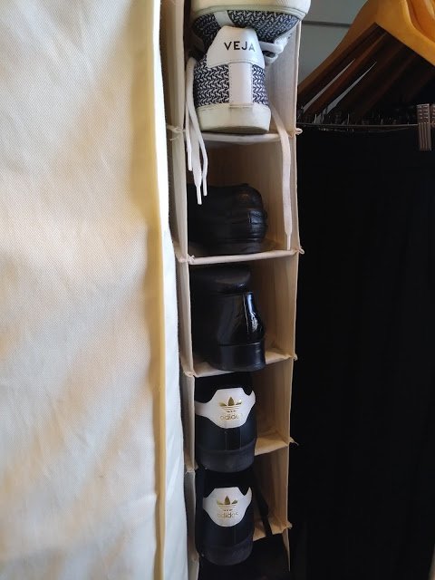 a canvas shoe holder with black and white shoes