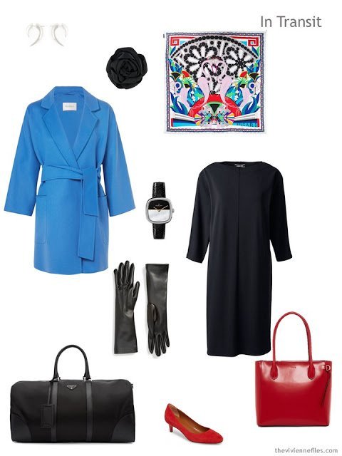 cool weather travel outfit of a black dress with blue coat and red leather accessories